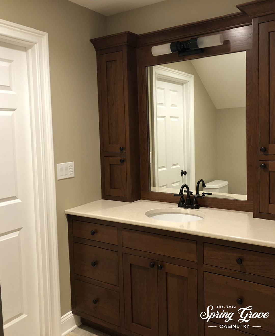 The private bathroom has a beautiful inset cherry vanity with two storage towers.